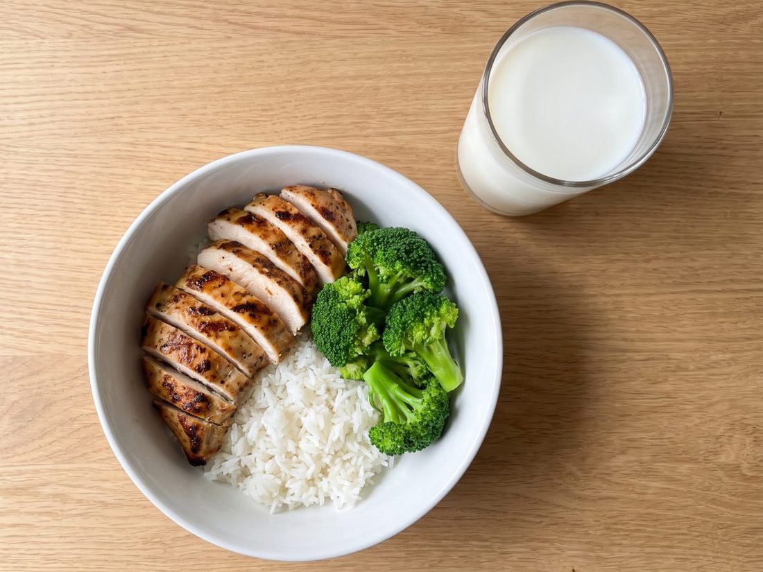 A chicken rice bowl with broccoli and a glass of milk